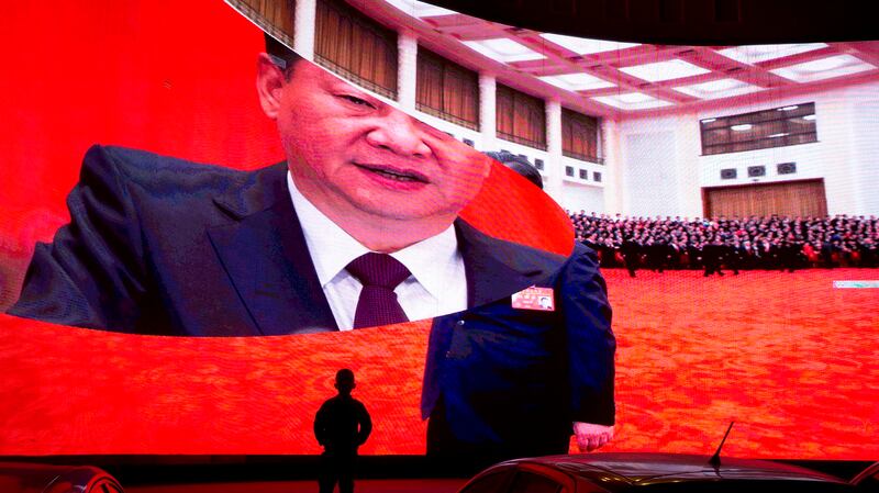 一名新疆儿童在观看电视大屏幕上的习近平。(美联社)