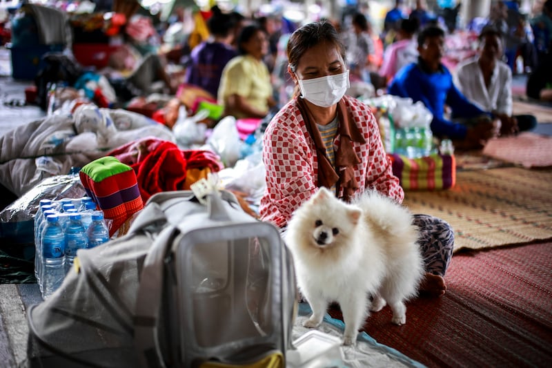 Juam, 50 sits next to her dog "Krati" inside a temporary shelter in Sisaket province,Thailand, July 26, 2025.