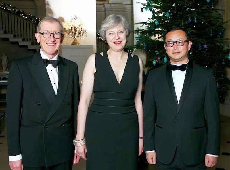 Yang Tengbo, right, stands with Theresa May and her husband, Philip, in this undated photo presented at a 2019 awards ceremony for Tengbo.