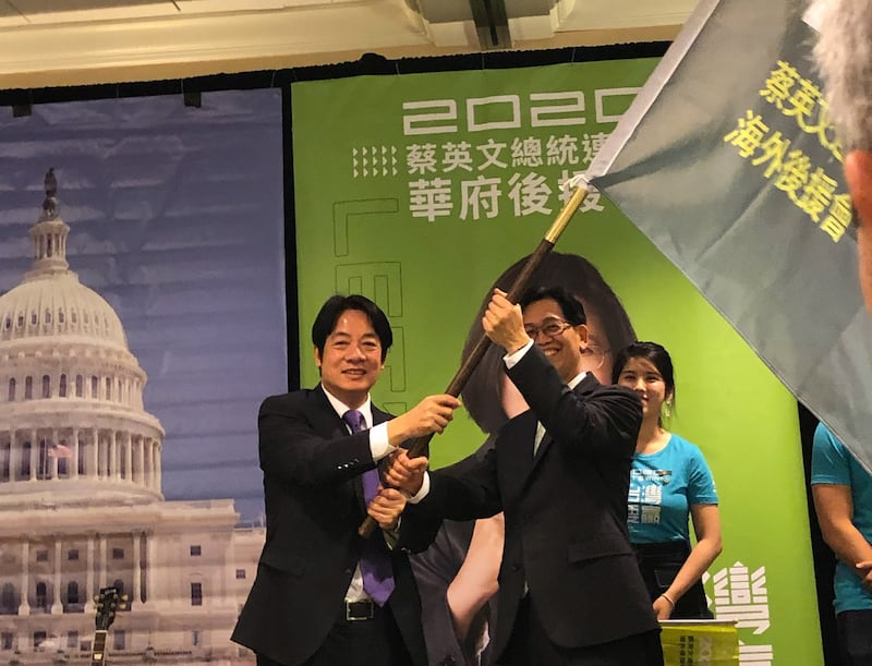 2019年10月19日,代表台湾民进党总统候选人蔡英文到华府参加造势大会的前行政院长赖清德在授旗仪式中将ㄧ面支持蔡英文连任的旗帜交给大华府小英后援会会长简明子 。