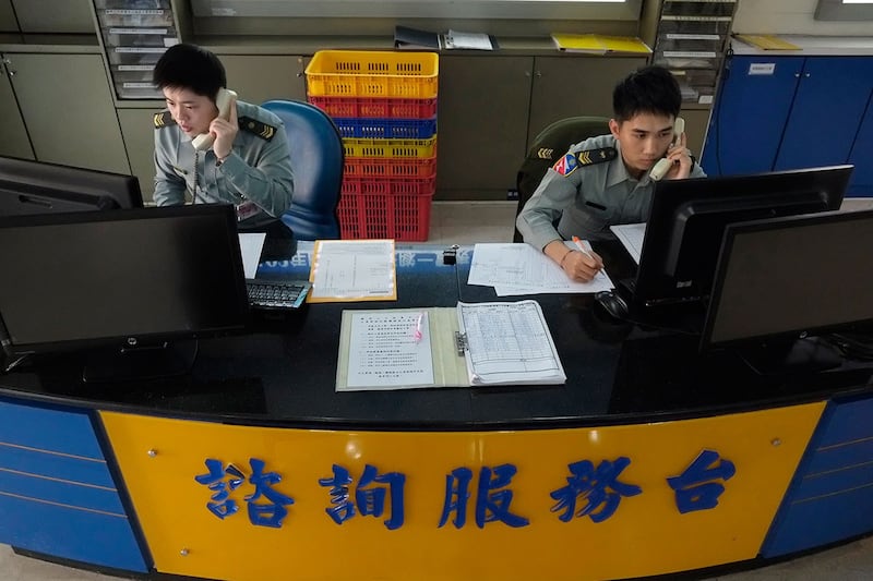 2013 年 3 月 22 日,士兵在征兵中心的问讯处接听电话,试图吸引年轻的台湾人到台湾台北志愿服务。(美联社)