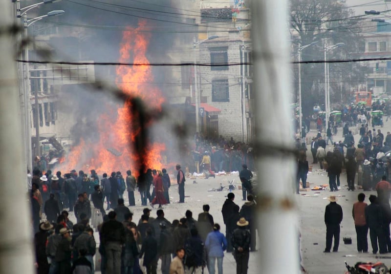 This March 14, 2008, photo shows protesters gathering around burning debris in the streets of Lhasa, Tibet Autonomous Region.